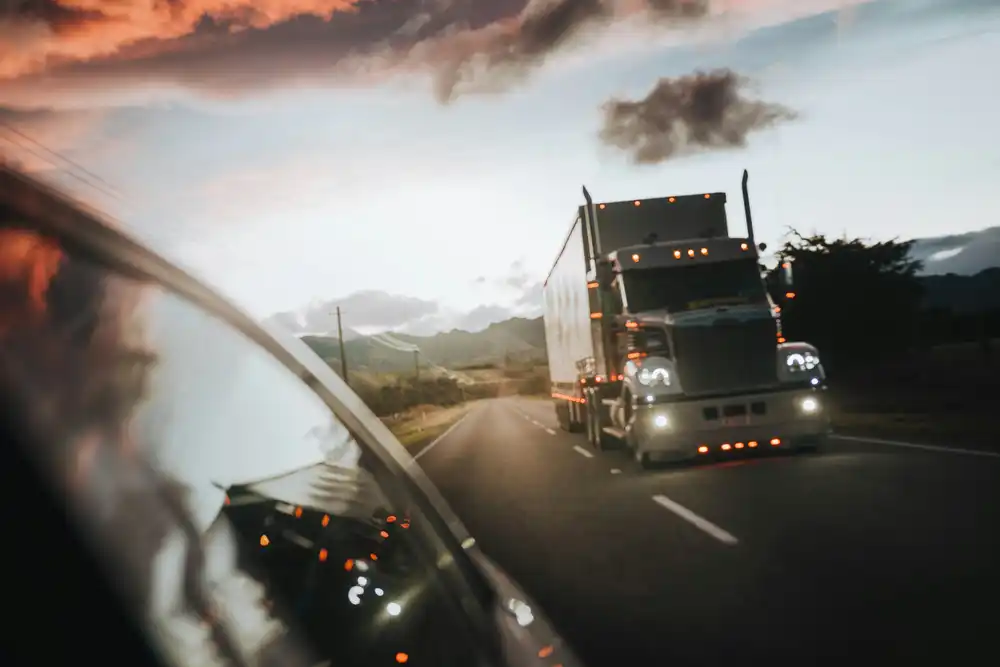 A truck driving on a highway at dusk